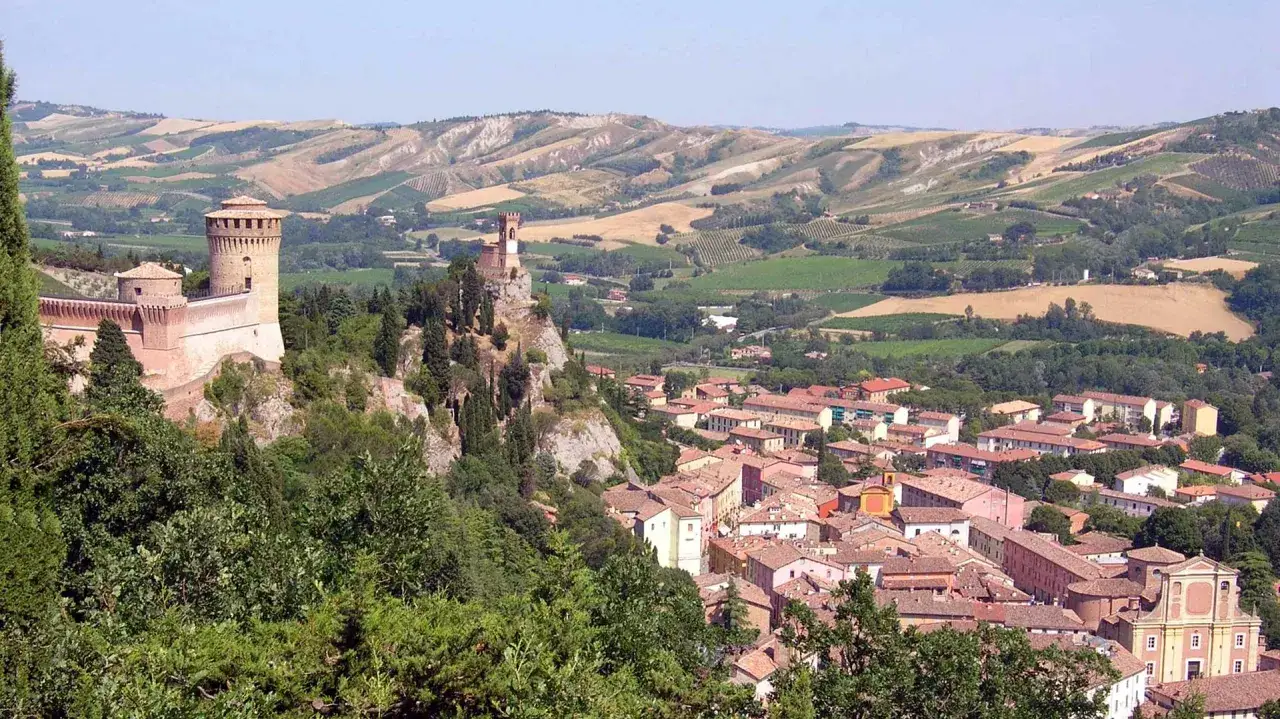 Un borgo medievale con un castello domina il paesaggio collinare di Brisighella, Italia.