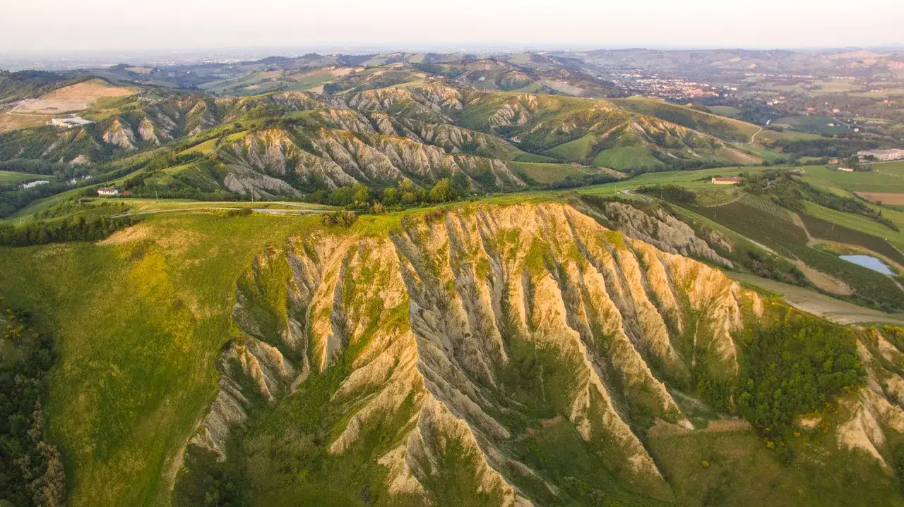 Colline ondulate e calanchi suggestivi, perfetti per il trekking in Emilia Romagna. Un paesaggio mozzafiato al tramonto.