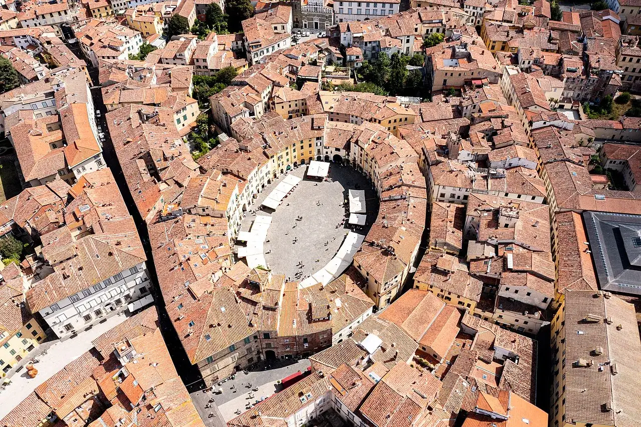 Vista aerea della piazza Anfiteatro di Lucca, con le sue case ovali e i tetti rossi che la circondano.