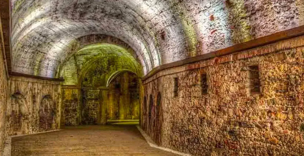 Interno suggestivo di una domus romana a Lucca, con volte in pietra e muri antichi illuminati da luci soffuse.