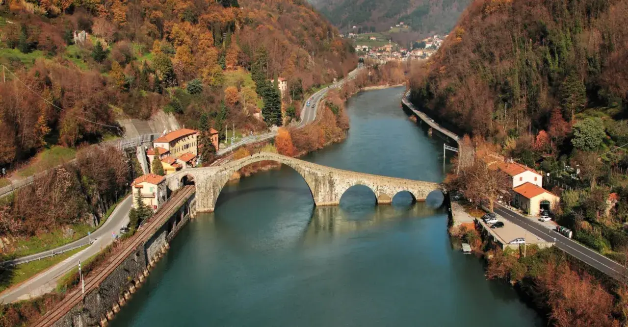 Ponte del Diavolo a Borgo a Mozzano, con il fiume Serchio e le colline autunnali.