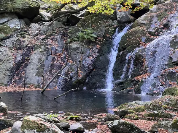 Cascate di Pontremoli in autunno, con foglie cadute che adornano rocce e specchi d'acqua.