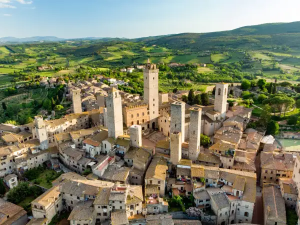 San Gimignano, con le sue torri medievali che svettano tra i tetti, incanta in un paesaggio collinare toscano.