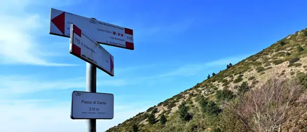 Segnaletica escursionistica sul **Monte Pisano**, indica il Passo di Dante a 215 m e sentieri per S. Giuliano Terme.