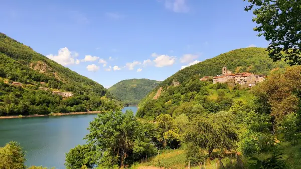 Villaggio tra colline verdi e lago, ideale per escursioni apuane facili.