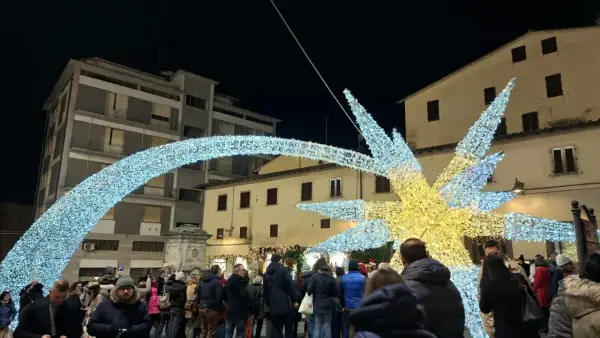 Luci natalizie scintillanti illuminano il poggibonsi markt, creando un'atmosfera magica tra la folla.