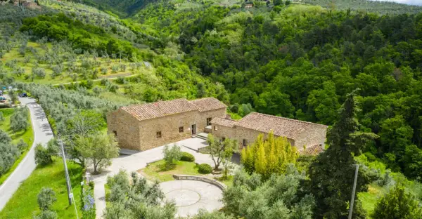 Casolare in pietra immerso nel verde della campagna di Vinci, Toscana, tra ulivi e boschi rigogliosi.