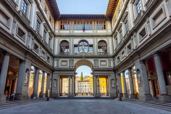 Cortile degli Uffizi, uno dei principali musei da vedere a Firenze. Architettura rinascimentale con statue e un arco che si apre sulla città.
