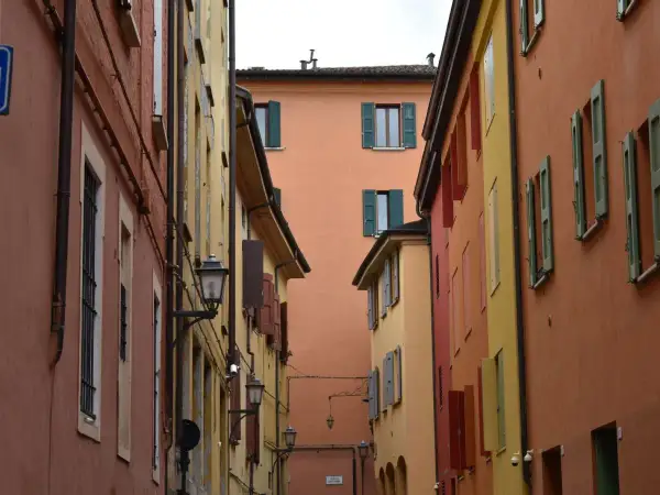Vicoli colorati, perfetti per gite fuori porta da Bologna. Case con persiane verdi e lampioni antichi creano un'atmosfera suggestiva.