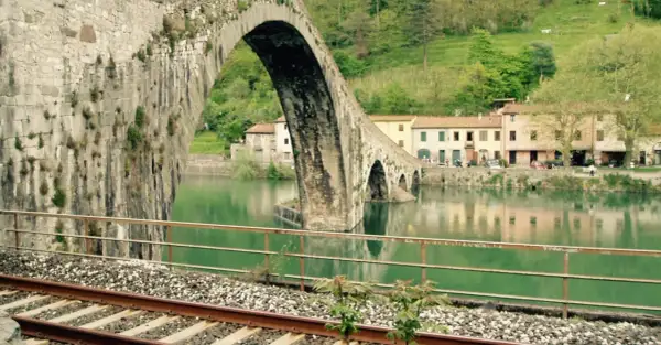 Ponte del Diavolo a Borgo a Mozzano, con case colorate e il fiume Serchio.