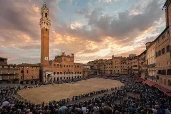 Piazza del Campo a Siena, gremita di spettatori in attesa del Palio. Cos'è il Palio di Siena? Una corsa di cavalli storica.